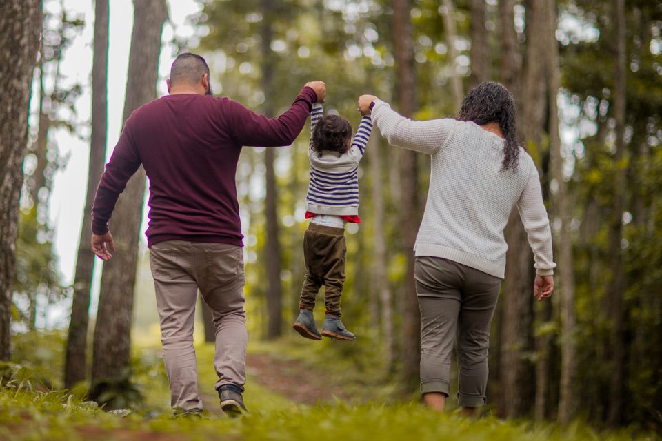 Parents lifting their child during a walk